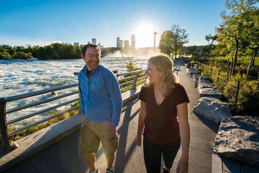 A happy couple hiking along a trail at Niagara Falls