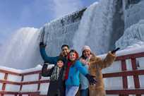 A family at the base of the falls in winter at Niagara Falls State Park