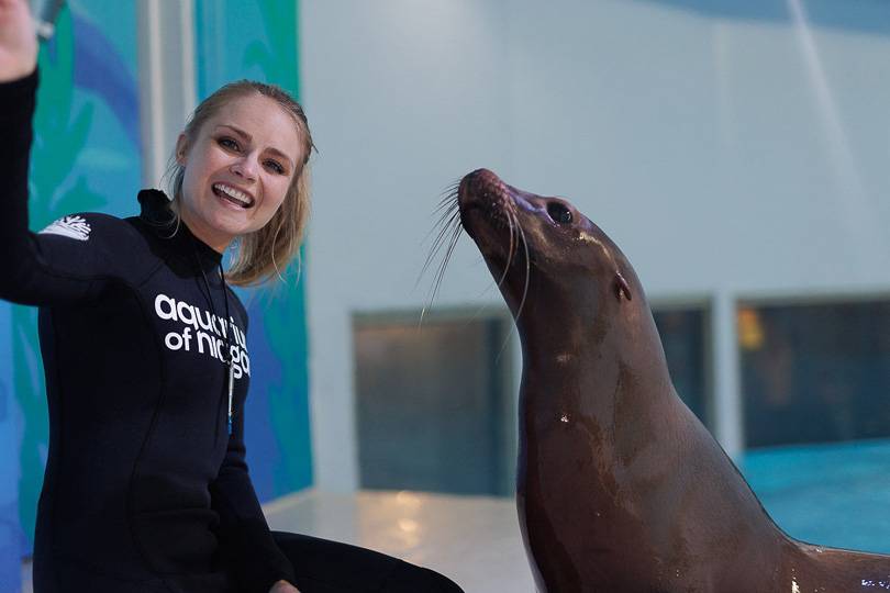 A trainer posing with a sea lion at Niagara Falls Aquarium