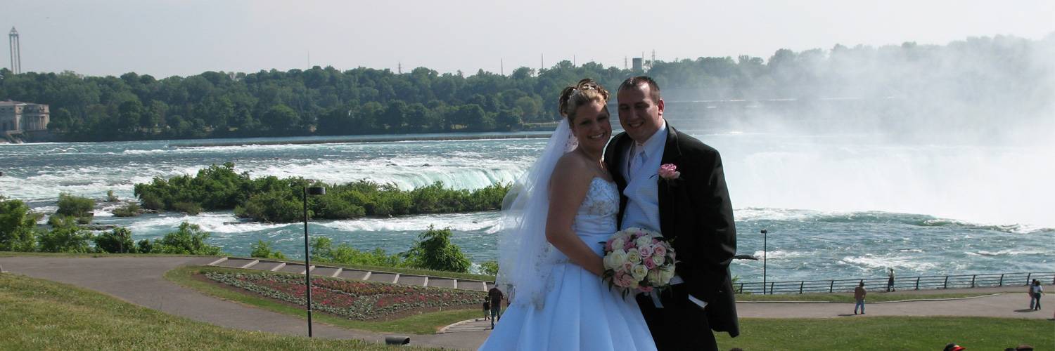 newly married couple in front of niagara falls